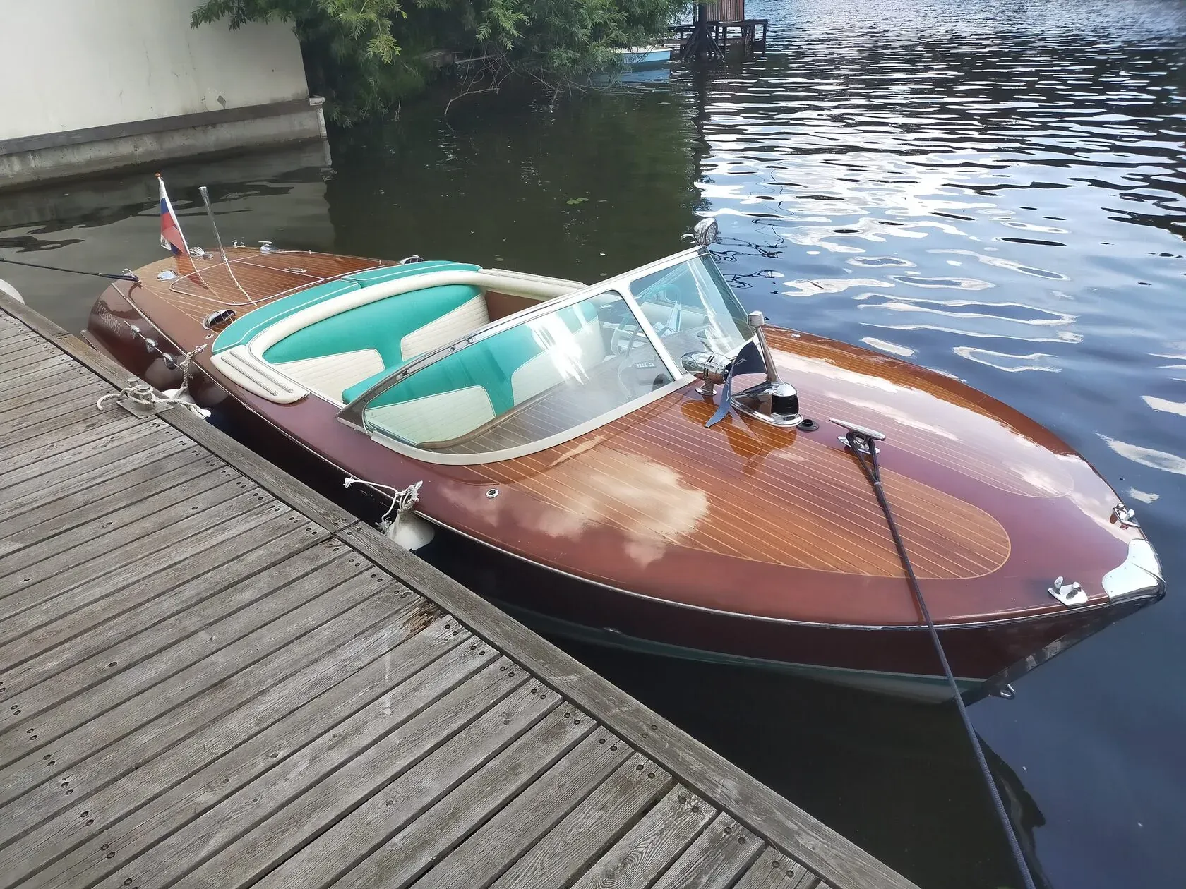 Капитан в жёлтой ветровке в Riva вечером на фоне марины с фонарями